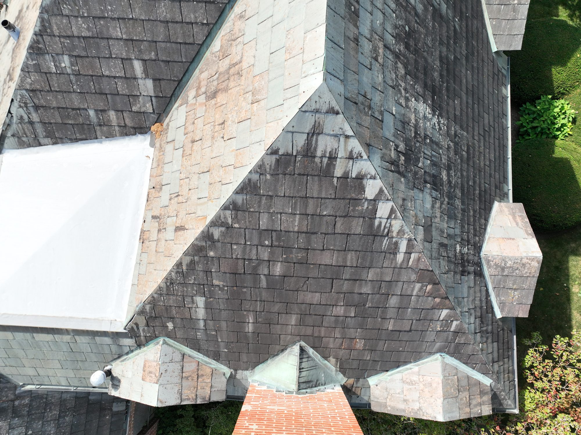 Side view of Bexley Colonial home slate roof with algae growth before cleaning