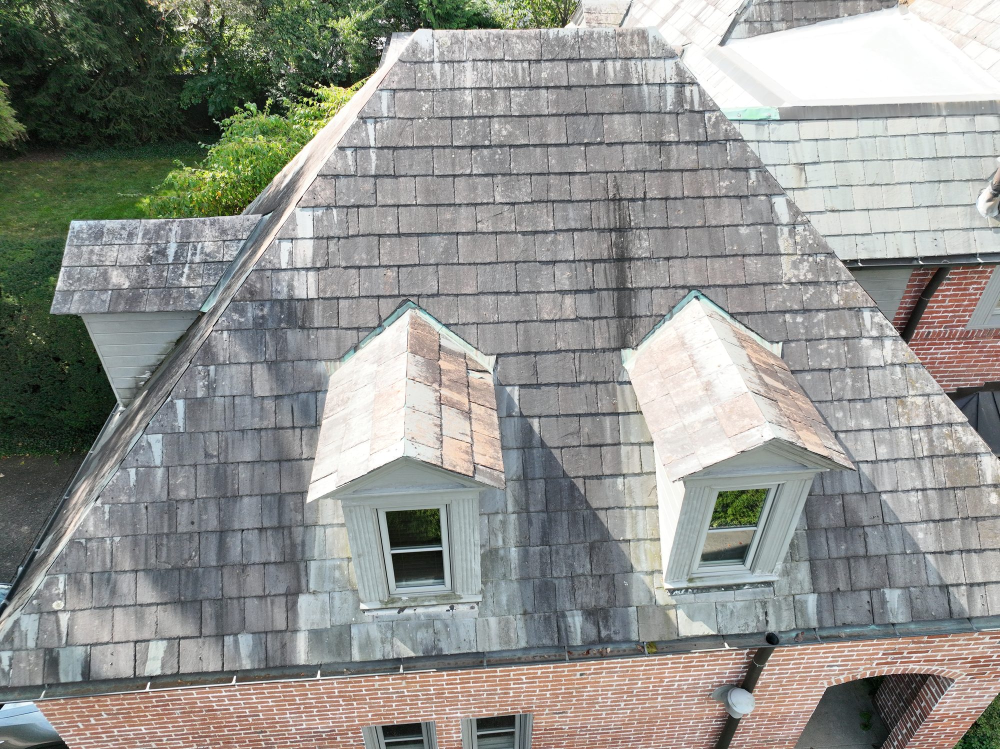 Rear gables of Bexley slate roof with organic growth before cleaning
