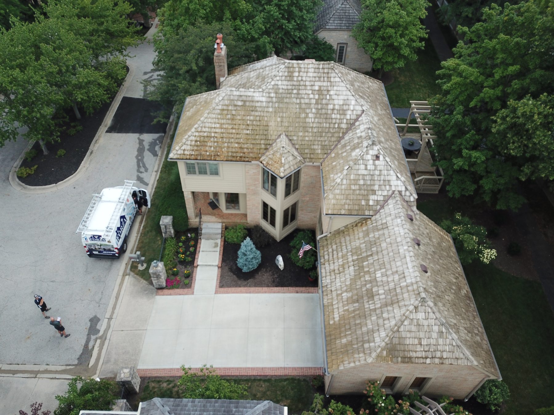After cedar roof cleaning - 45-degree front view of cedar shake roof still wet showing partial color restoration on cul-de-sac home in Muirfield Village Dublin Ohio