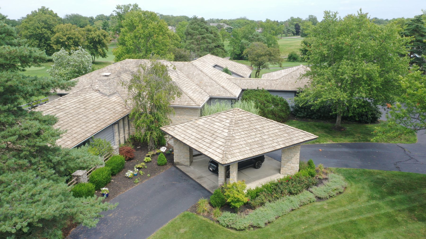 After cedar roof cleaning - 45-degree view of restored cedar shake ridge line with golf course visible in Muirfield Village Dublin Ohio