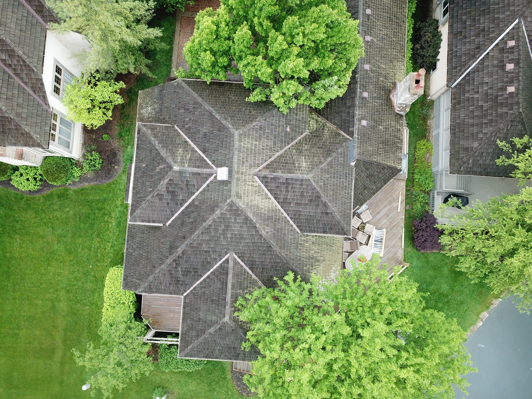 Before cedar roof cleaning - chimney area with algae and moss on cedar shakes in Muirfield Village Dublin Ohio
