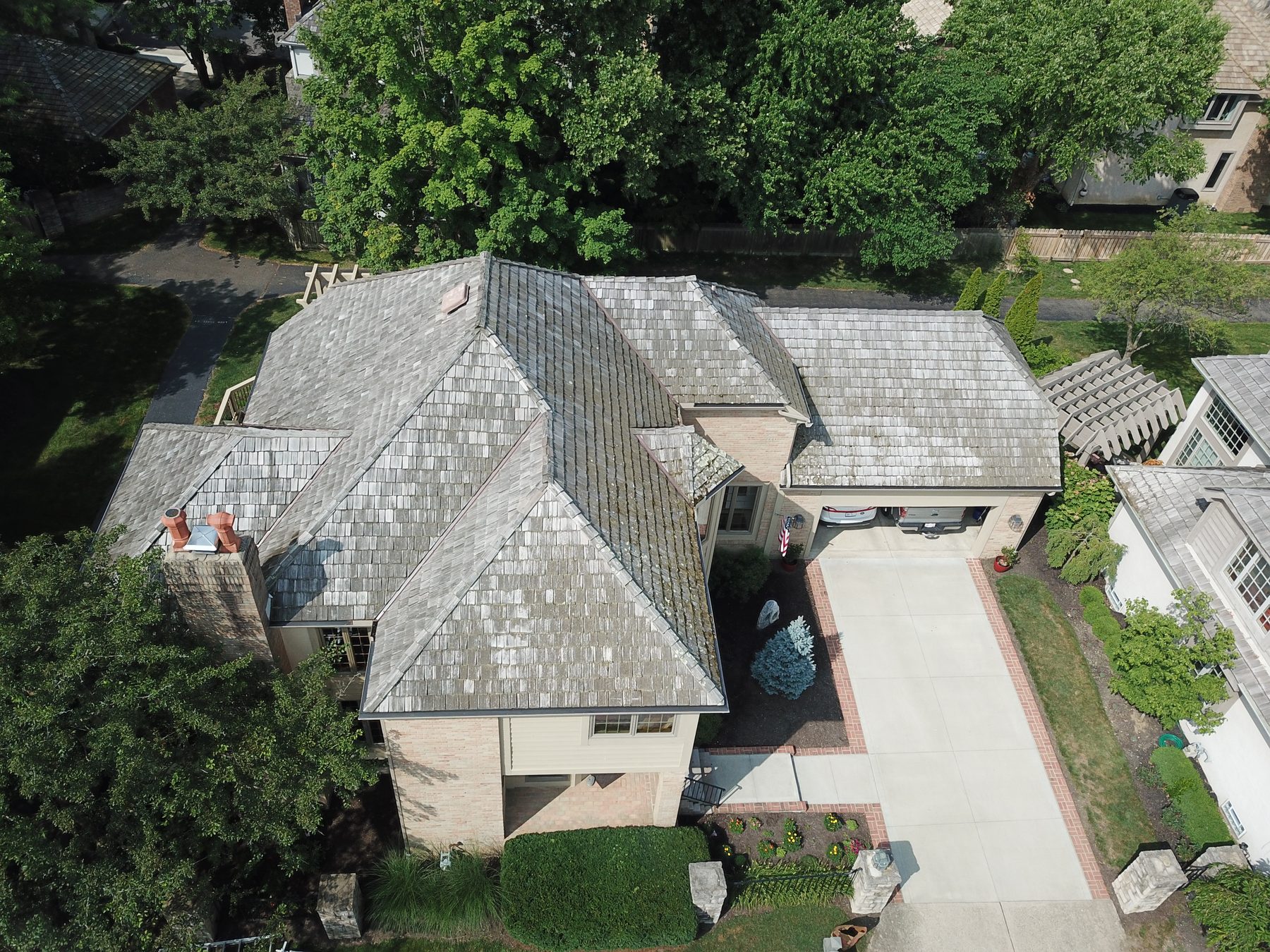 Before cedar roof cleaning - 45-degree front view of cedar shake roof with algae and streaks on cul-de-sac home in Muirfield Village Dublin Ohio