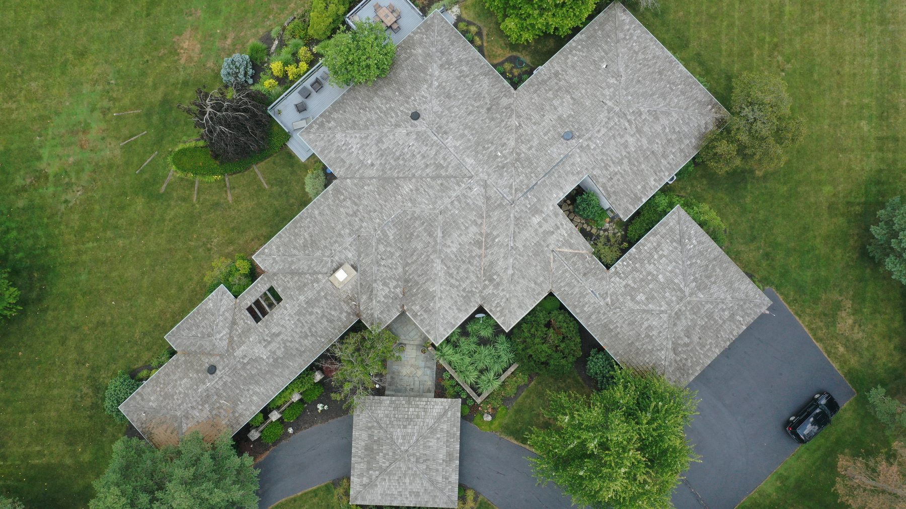 Before cedar roof cleaning - overhead view of cedar shake roof with black streaks algae and debris near golf course fairway in Muirfield Village Dublin Ohio