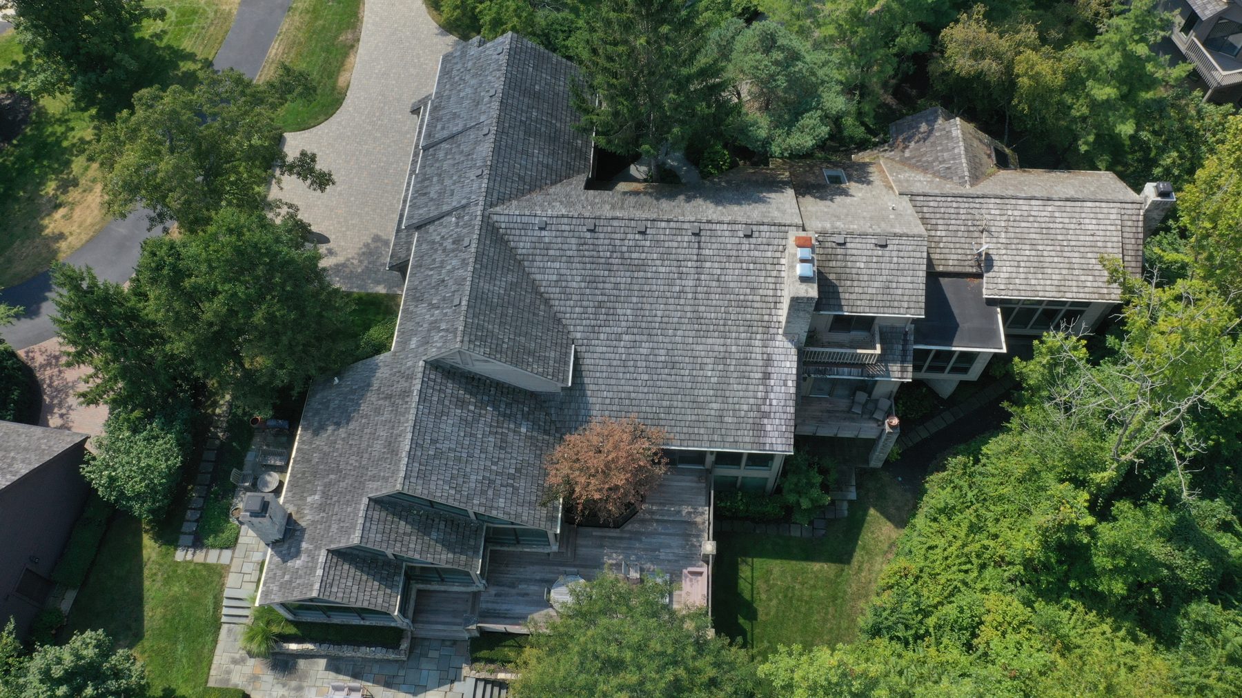 Before cedar roof cleaning - overhead view of cedar shake roof with algae black streaks and complex roofline in Muirfield Village Dublin Ohio