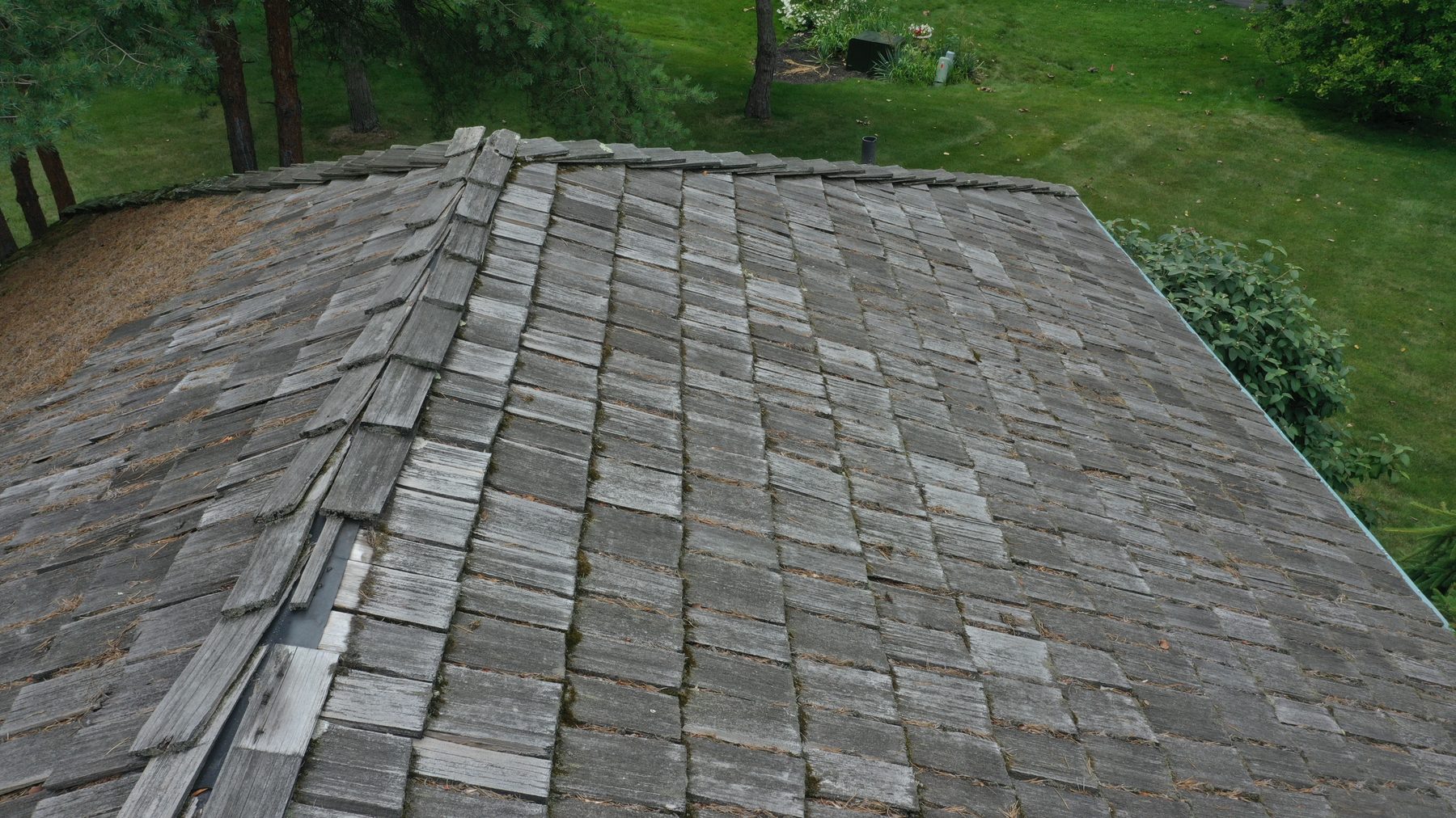 Before cedar roof cleaning - 45-degree view of cedar shake ridge line with moss debris and weathering near golf course in Muirfield Village Dublin Ohio