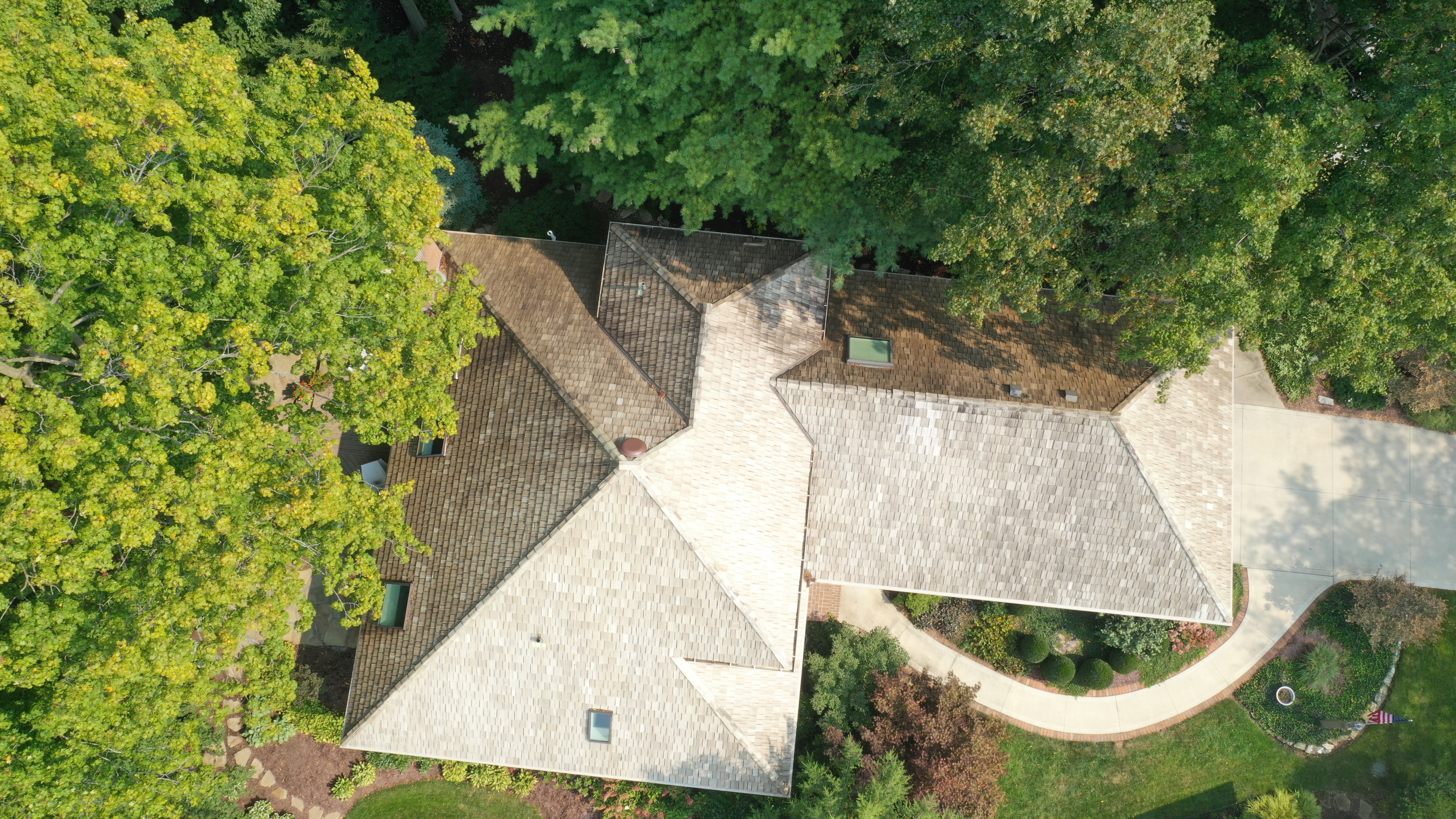 After cedar roof cleaning - full overhead view showing golden-tan cedar shakes, American flag at curb, driveway and landscaping visible, The Sanctuary Columbus Ohio
