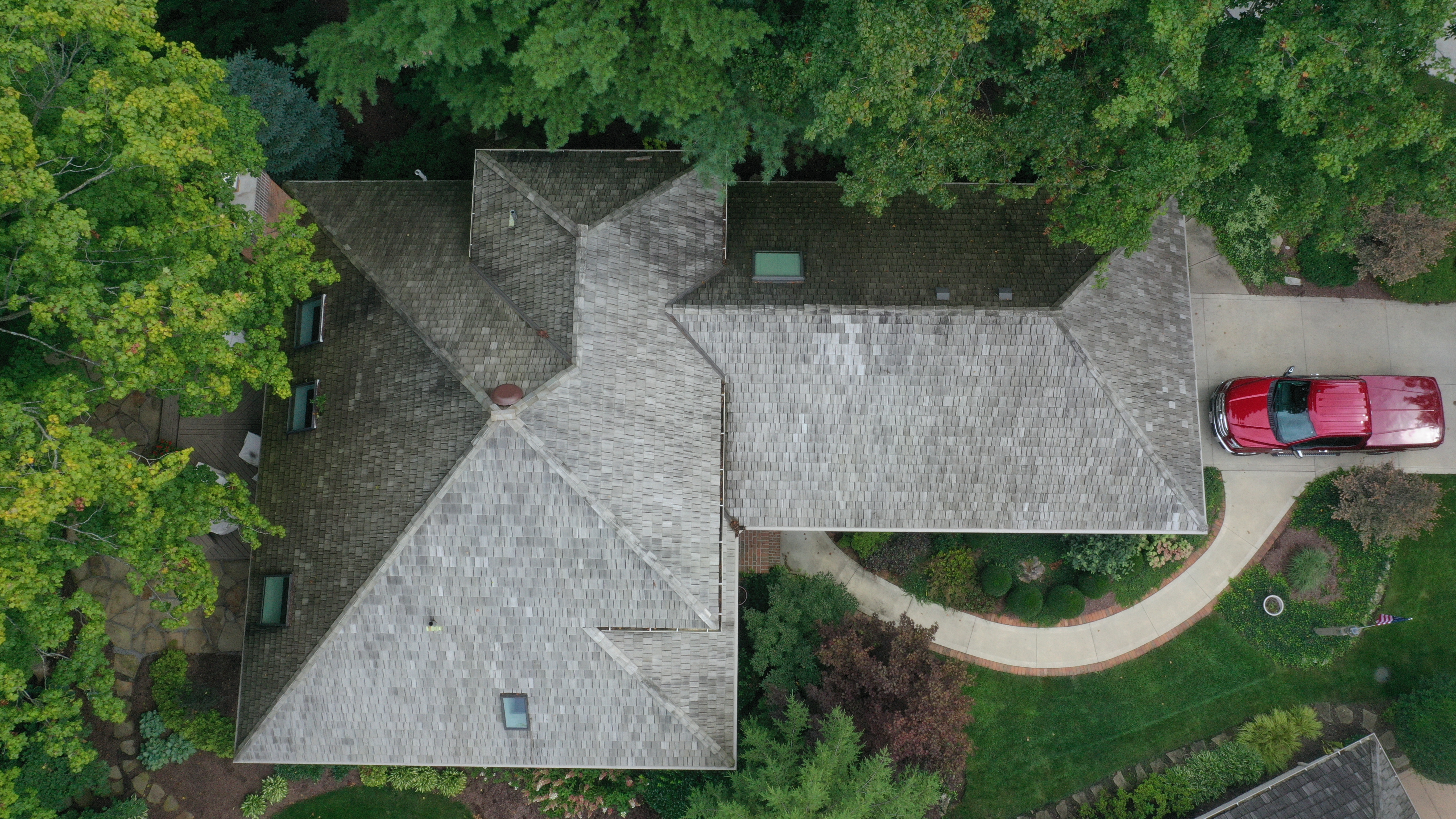 Before cedar roof cleaning - overhead view of massive estate cedar shake roof with dark gray-black weathering, multiple skylights, Forza van in curved driveway, The Sanctuary Columbus Ohio