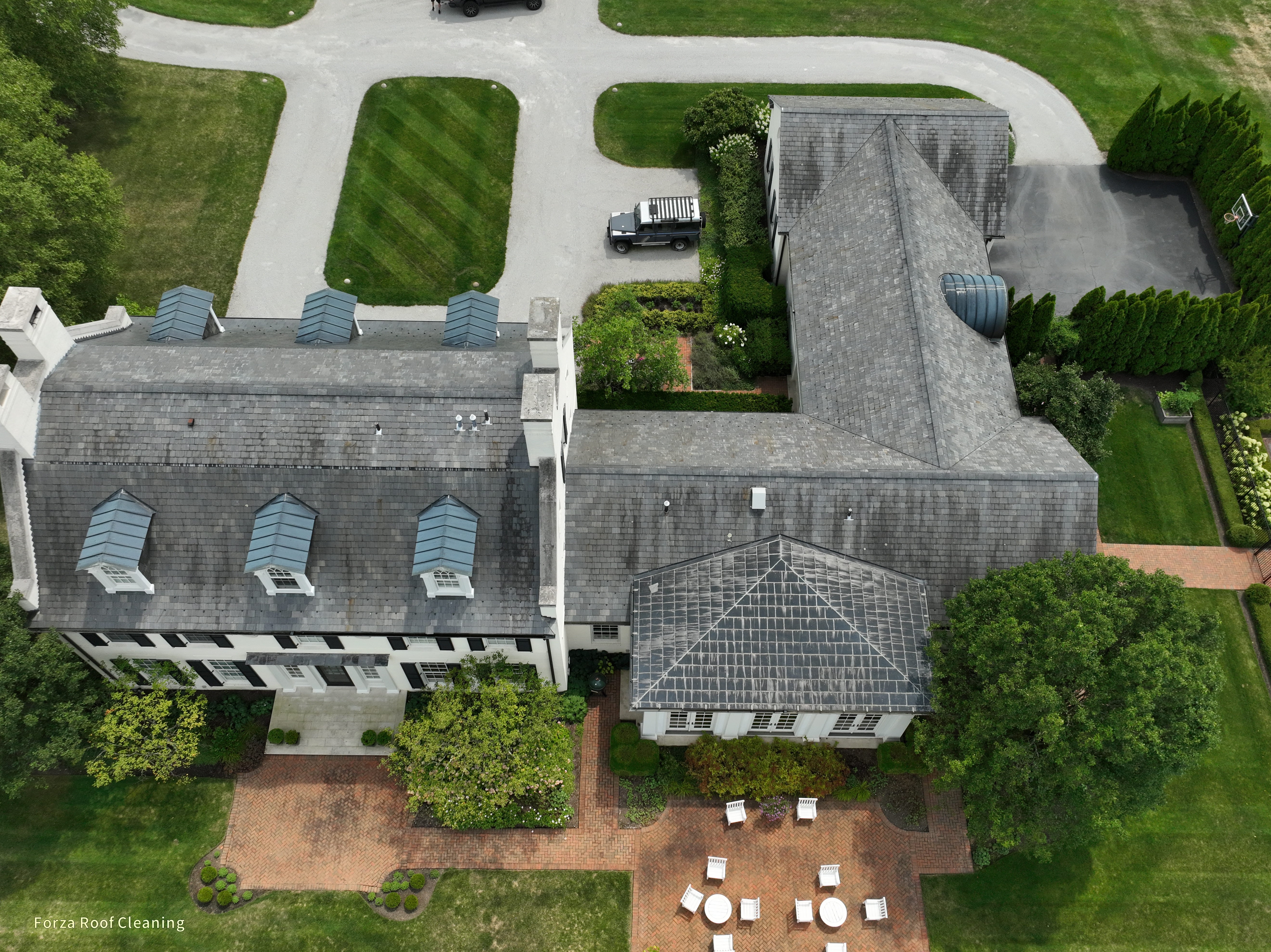 Before slate roof cleaning - aerial view of slate roof with dark algae staining on estate home in New Albany Ohio