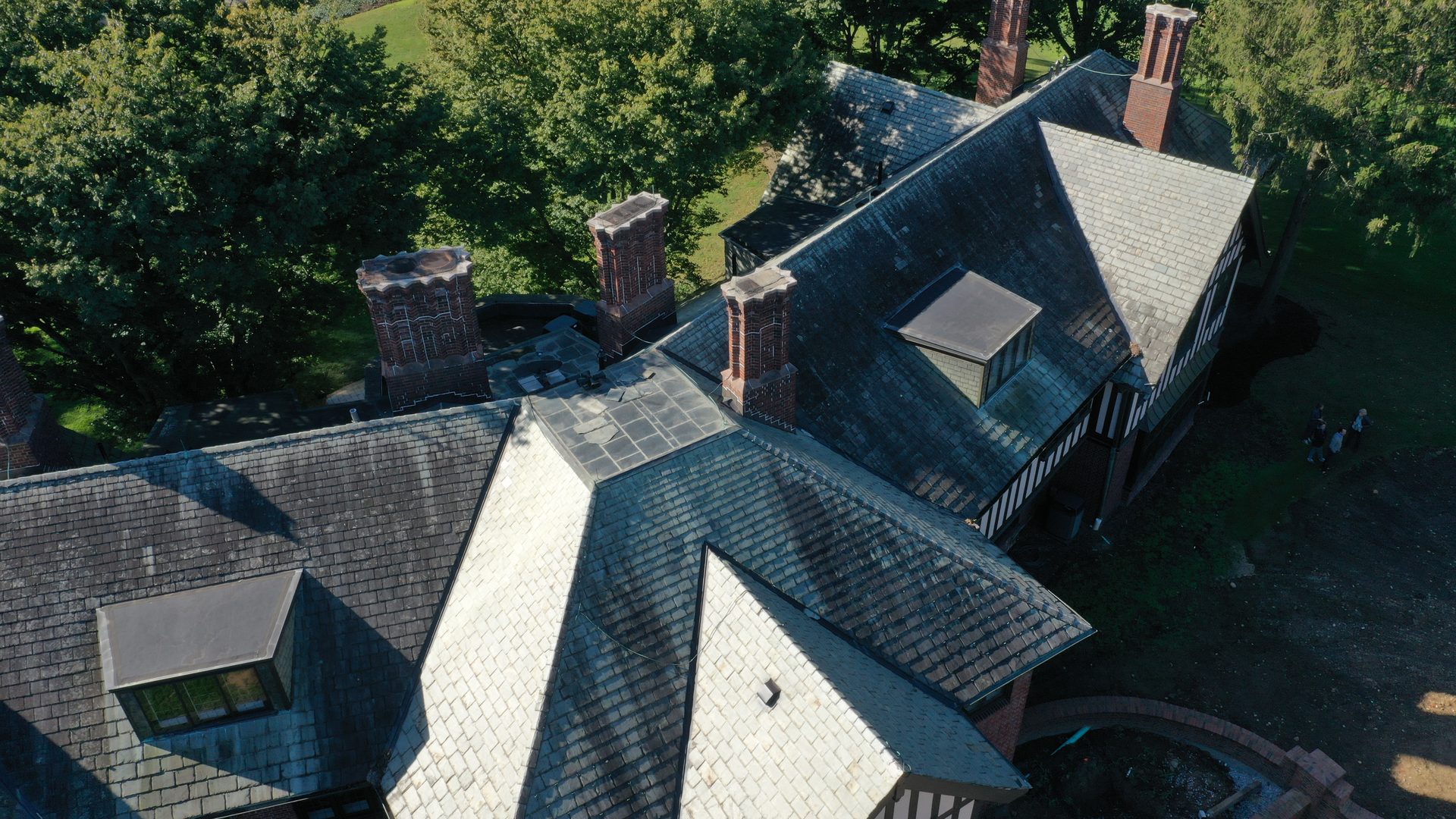 Large Tudor mansion slate roof covered in organic growth before Forza roof cleaning in Bexley