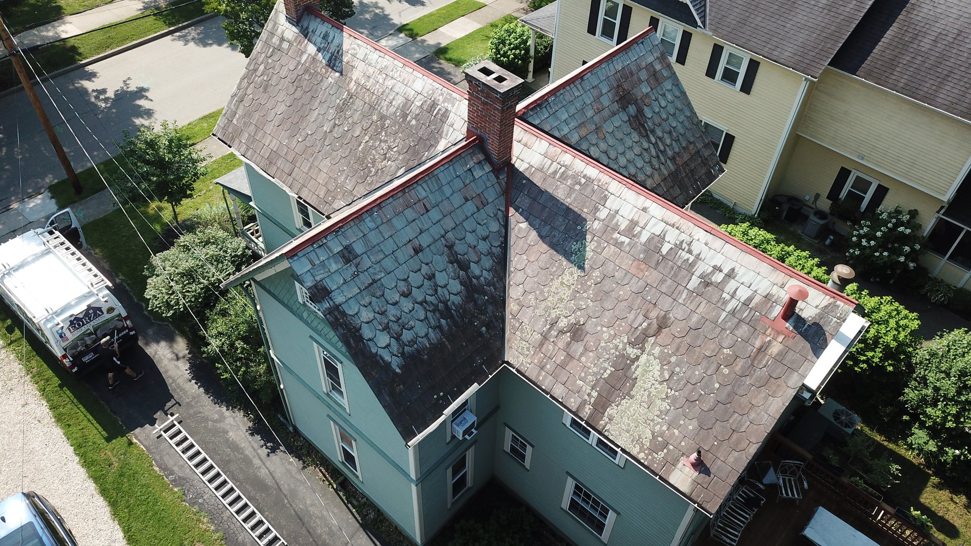 Before roof cleaning in Granville Ohio — heavy lichen and moss on historic slate roof