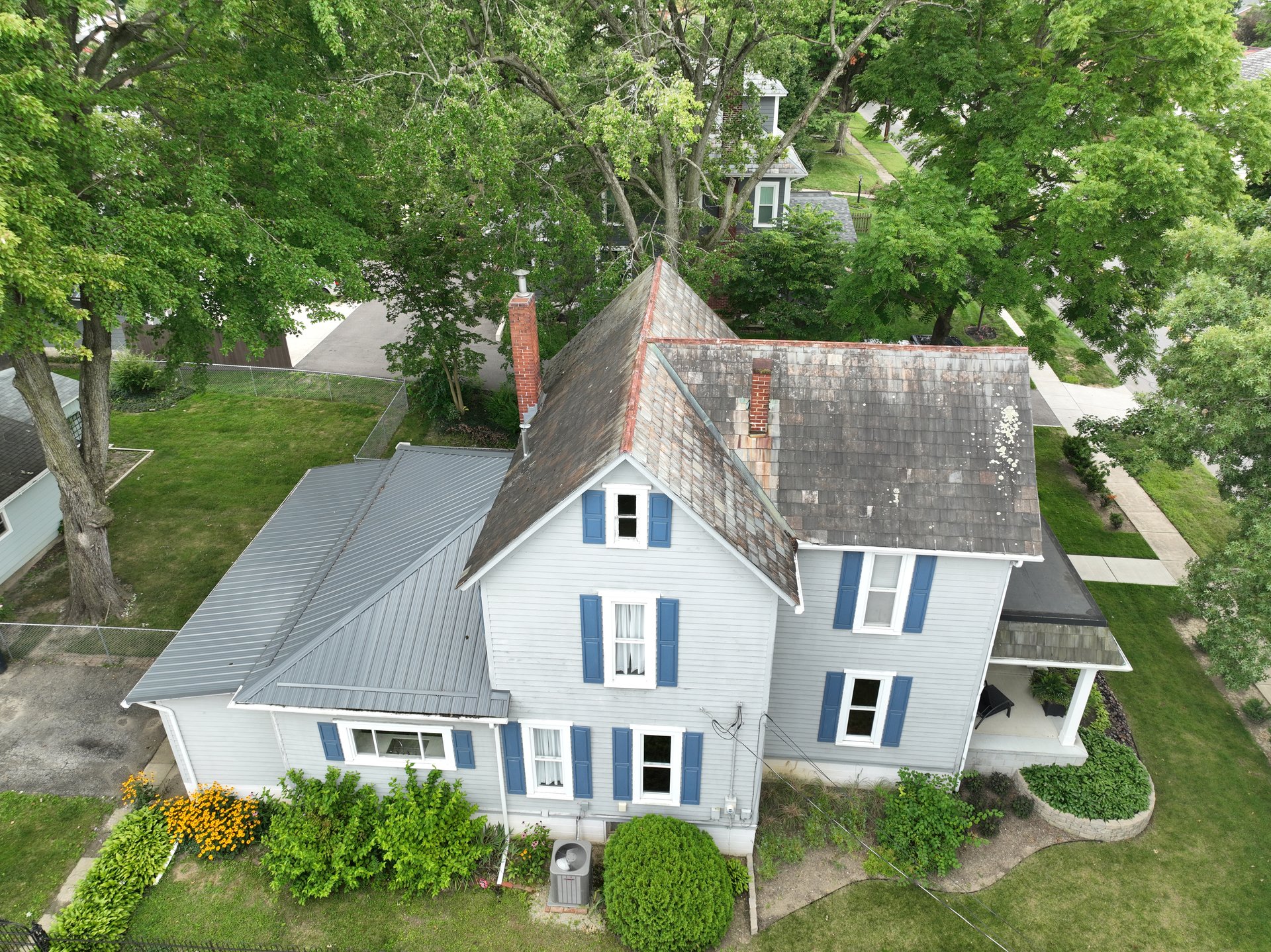 Before roof cleaning in Johnstown Ohio — heavy lichen on slate and metal mixed roof