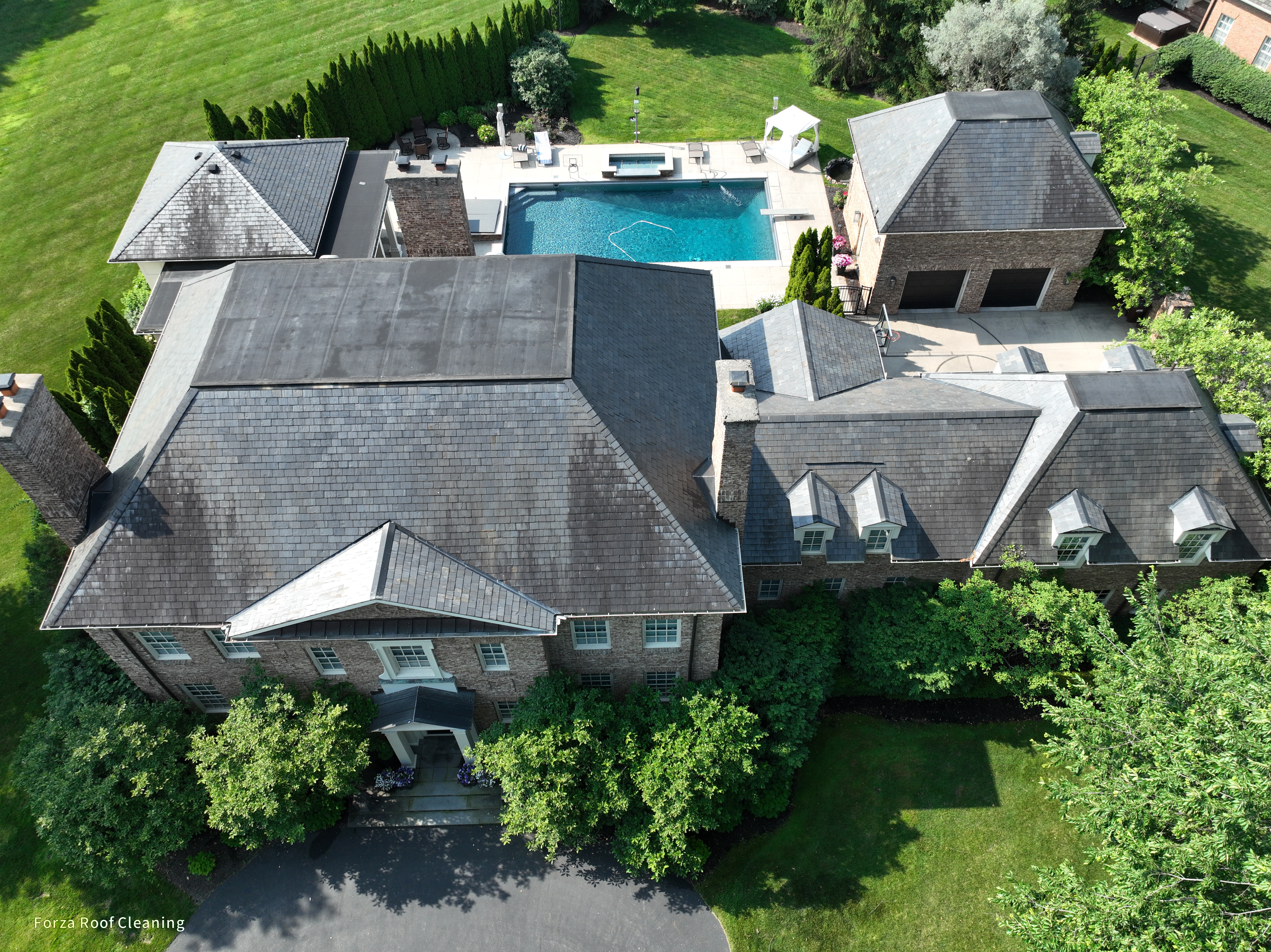 Before slate roof cleaning - aerial view of slate roof with dark algae staining on luxury estate in New Albany Ohio