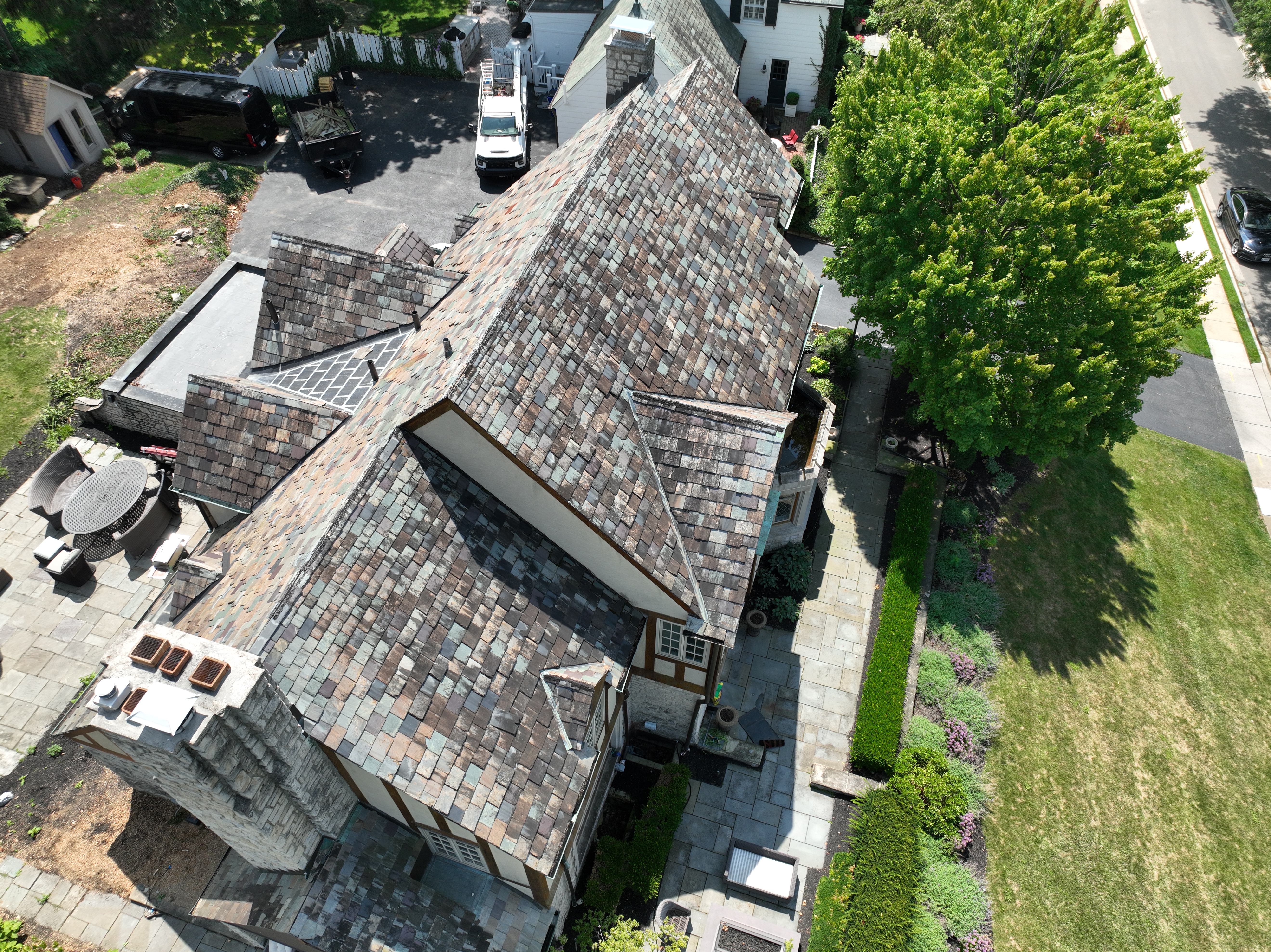Tudor revival slate roof in Upper Arlington before cleaning showing dark algae staining over multi-color slate